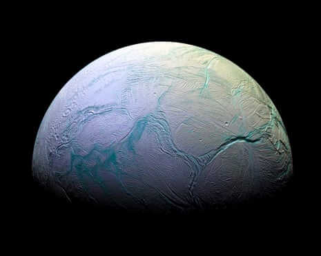 A photograph of Enceladus in space, a marbled white moon with streaks of blue