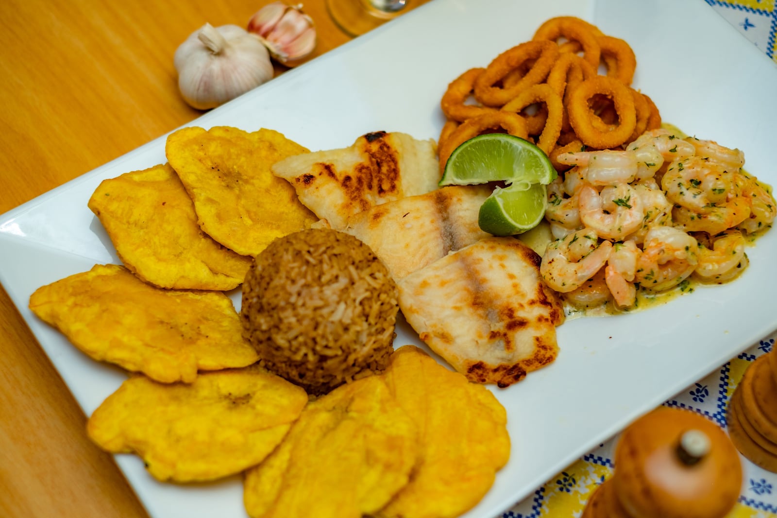 Prato de frutos do mar apetitoso com camarões, peixe, tostones e arroz com guarnição de limão. Jesus Cabrera