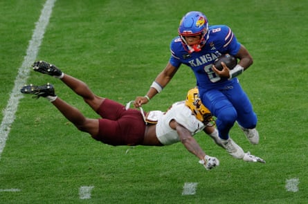 Montana Warren, a defensive back from Arizona, tries a flying tackle but just fails to sack Kansas quarter-back Isaiah Marshall.