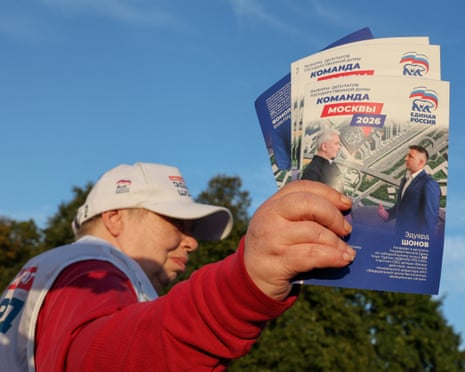 A volunteer handing out flyers for a United Russia candidate in Moscow.