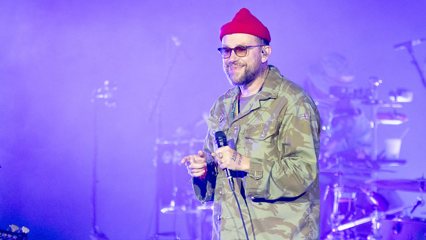 O vocalista da banda Gorillaz, Damon Albarn, segura uma bandeira palestina durante um show após a remoção de Macklemore do tour.