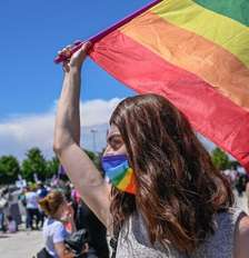 Integrante da comunidade lésbica, gay, bissexual, transgênero queer, intersexo e assexual (LGBTQIA+) segura uma bandeira do arco‑íris, símbolo da comunidade, durante um protesto contra a retirada da Turquia da Convenção de Istambul, em 19 de junho de 2021. Foto: AFP - BULENT KILIC / RFI