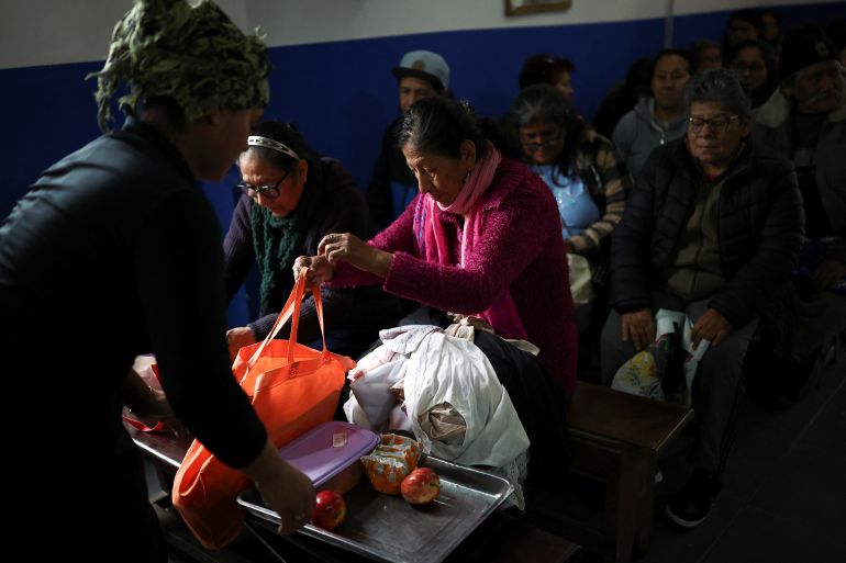 People sit inside a chapel while waiting for a meal distribution, as soup kitchens, barter clubs and families taking out short-term loans for groceries are exposing the social strains emerging under Argentine President Javier Milei's austerity program, barely a year before Argentina's next presidential election, in Buenos Aires' Villa 31 neighborhood, Argentina, August 28, 2026 [Agustin Marcarian/Reuters]