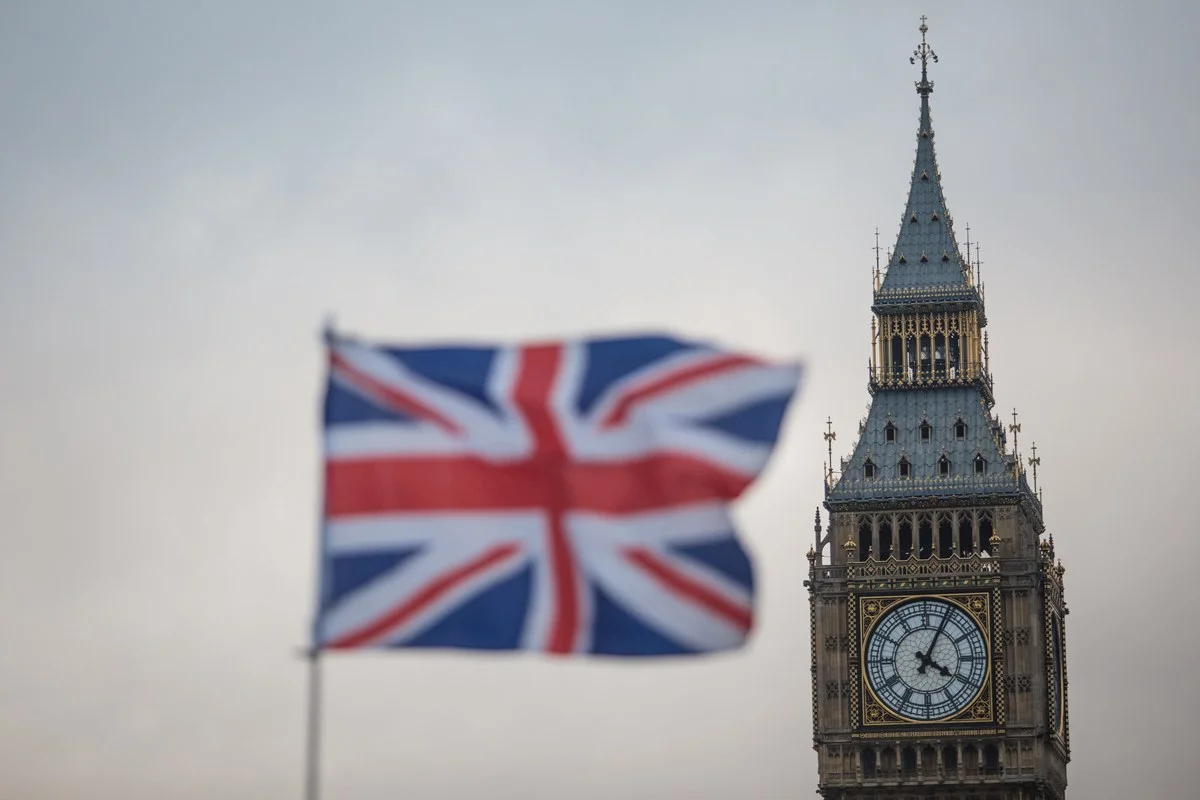 Imagem colorida da bandeira do Reino Unido. Ao fundo, o Big Ben - Metrópoles