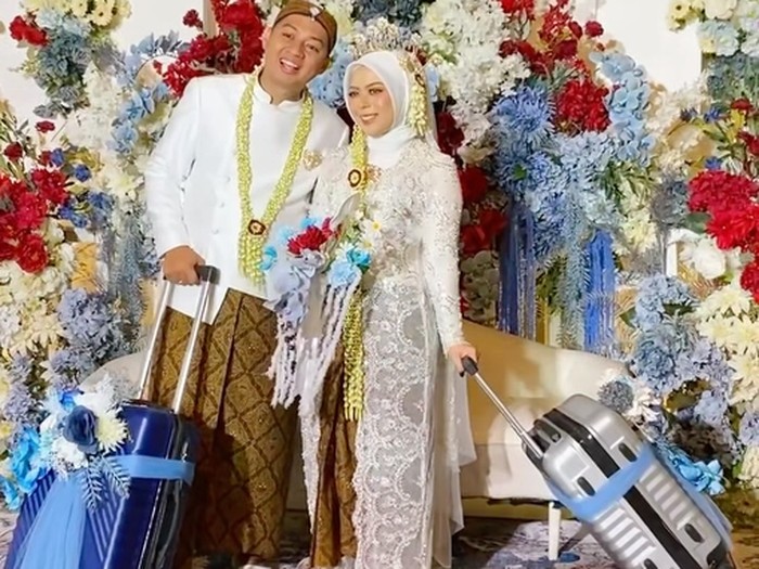 Suasana pengantin membawa koper saat di pelaminan bikin warganet salah fokus.