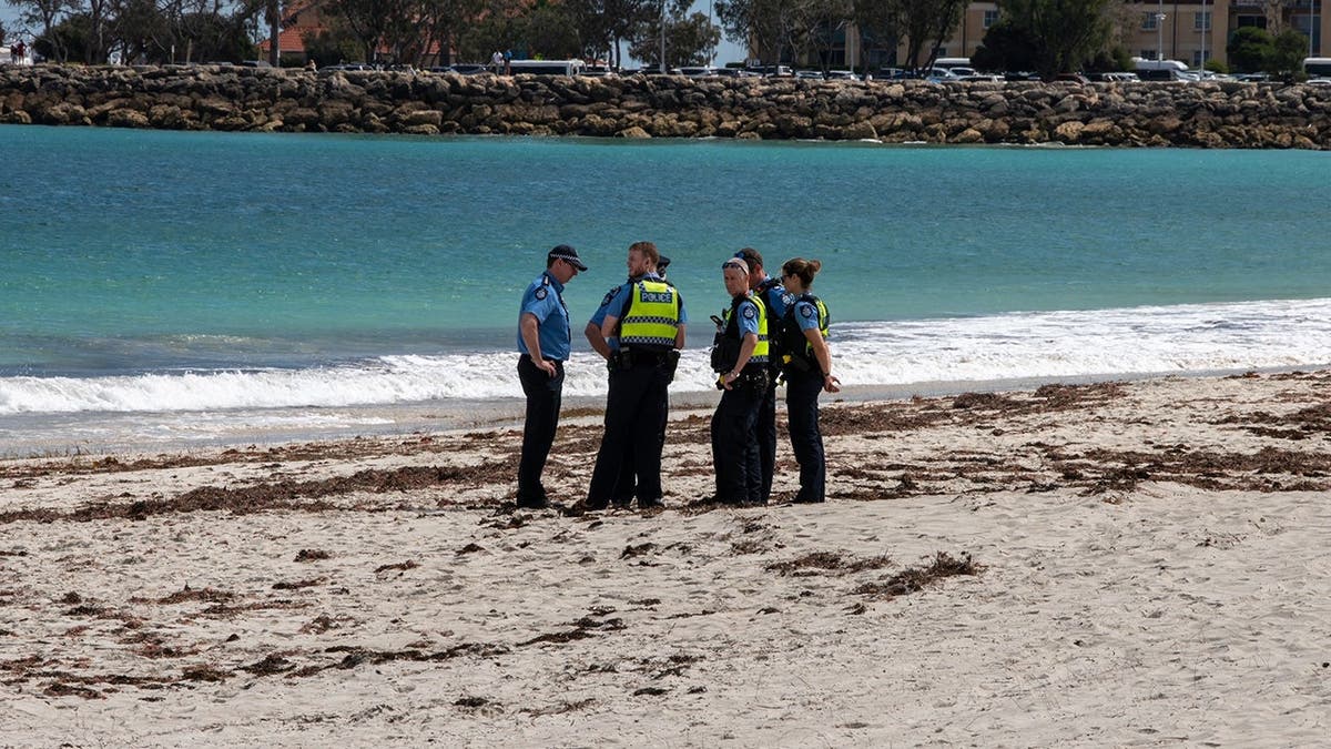 Police stand on Sorrento Beach in Perth, Australia.