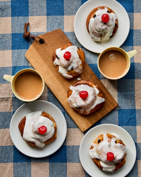 Benjamina Ebuehi's iced Belgian buns with cherries on plates, beside cups of tea