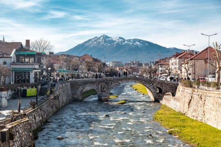 River running through town with mountain in background