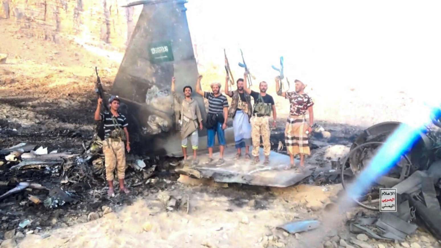 Combatentes houthis diante do que afirmam ser os destroços de um avião de combate saudita abatido, em local não especificado no Iêmen, em imagem extraída de um vídeo divulgado em 16 de setembro de 2026.