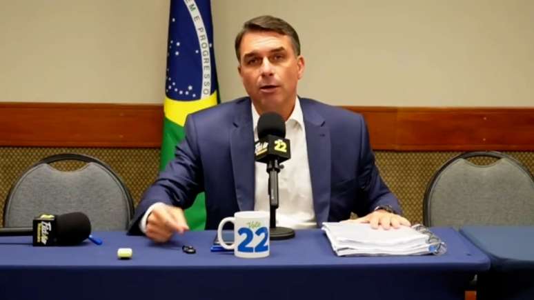 Após debate cancelado, Flávio Bolsonaro culpa Lula por 'interferência judicial', improvisa live com aliados e faz campanha por voto útil
